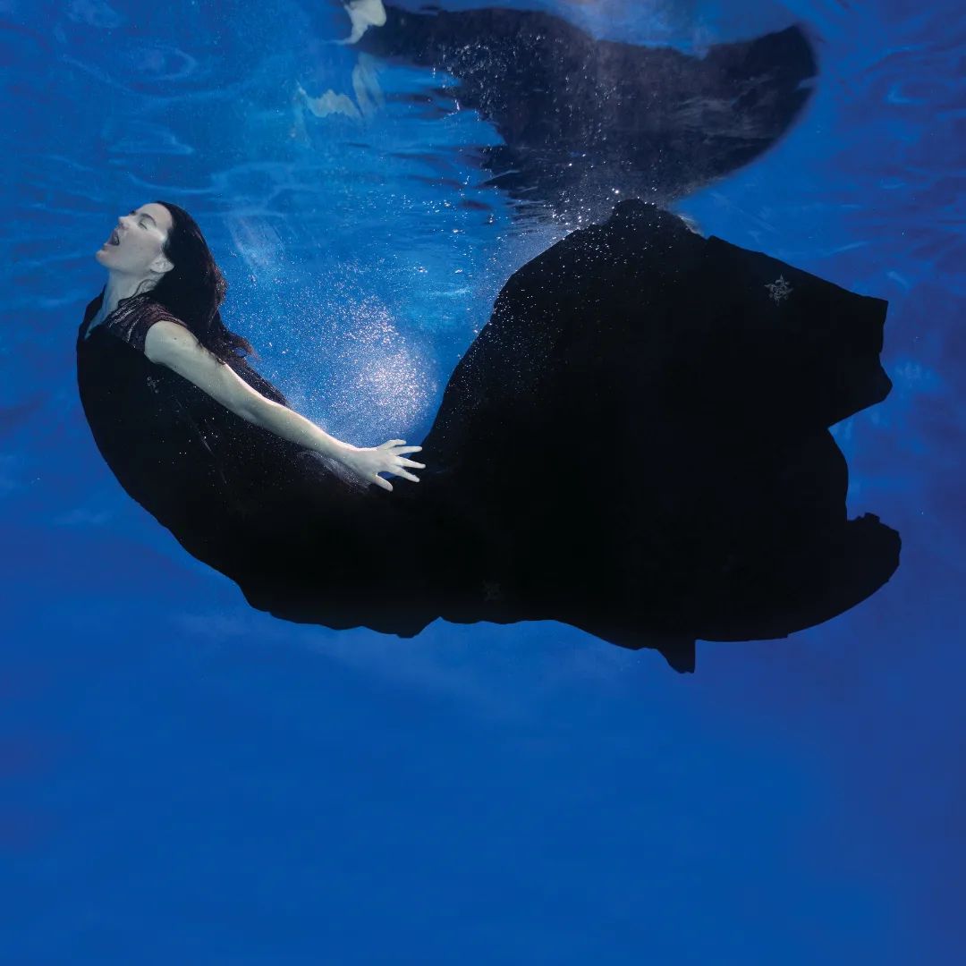 woman in black ball gown swimming underwater