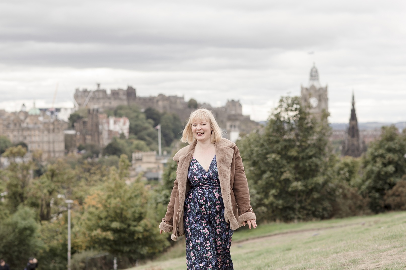 business woman walking with edinburgh skyline in the background